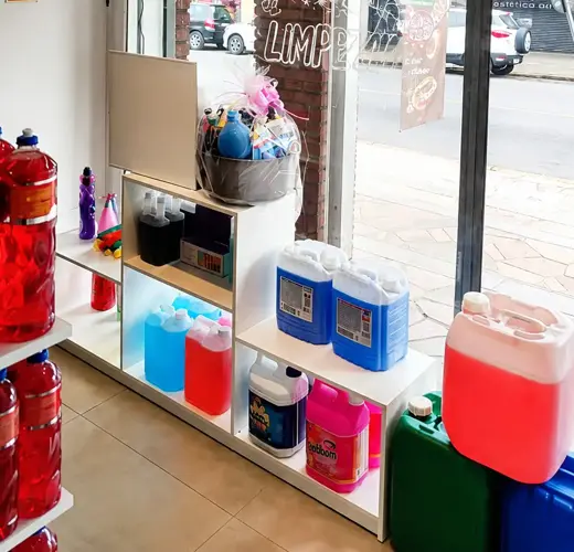 Visão interna da vitrine da Magia da Limpeza em Canoas, com galões de produtos e kits em exposição